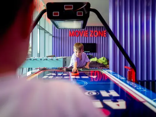 Kids playing air hockey in Ezone Centara Mirage Beach Resort Dubai