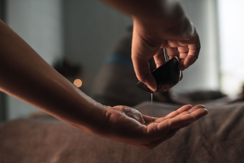 A massage therapist pouring oil before a massage
