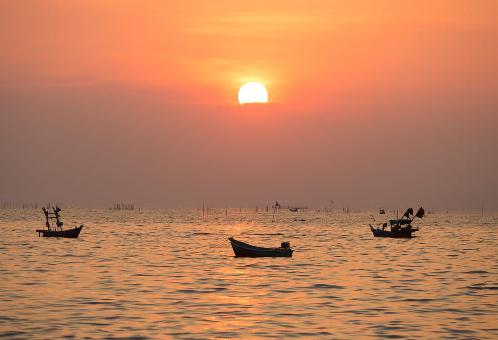 Thai fishing boats at sea during a dramatic sunset